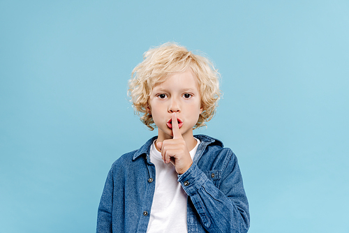 cute kid showing secret gesture and  isolated on blue