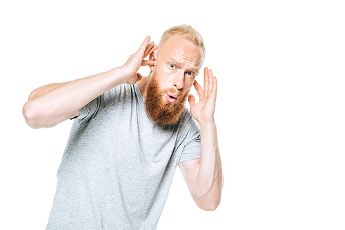 worried bearded man in grey t-shirt closing his ears from loud sound, isolated on white