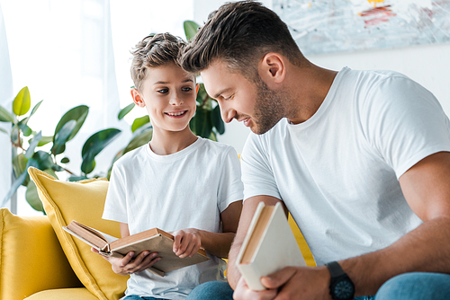 selective focus of happy father and son holding books