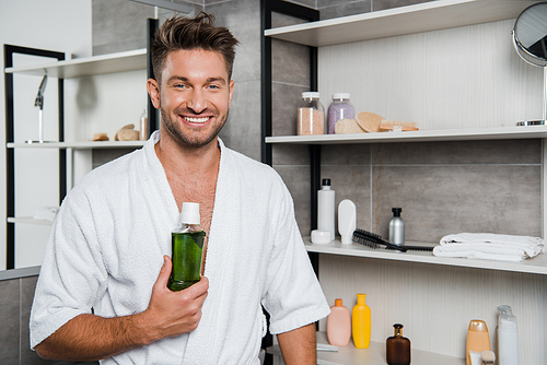 happy man holding bottle with green mouthwash