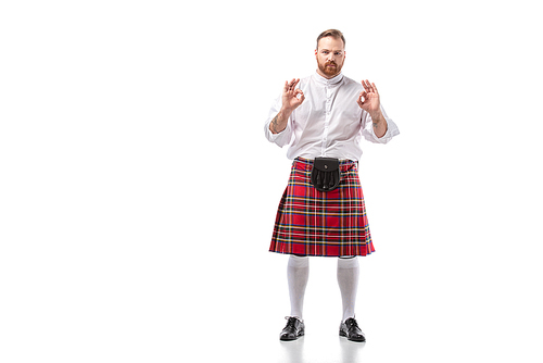 Scottish redhead bearded man in red tartan kilt showing ok gestures on white background
