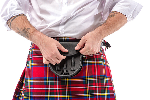 cropped view of Scottish man in red kilt touching leather belt bag isolated on white