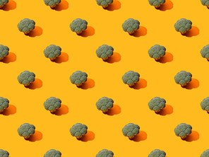 fresh green broccoli on orange background, seamless pattern