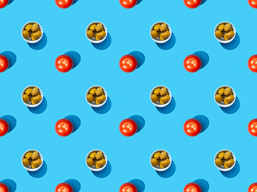 top view of olives in bowls and tomatoes on blue colorful background, seamless pattern