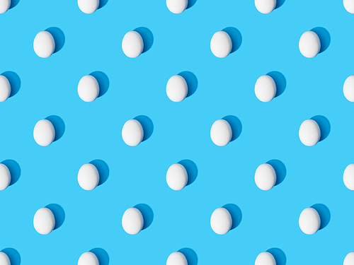 top view of fresh chicken eggs on blue background, seamless pattern