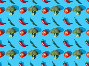 top view of fresh green broccoli, chili peppers and tomatoes on blue background, seamless pattern
