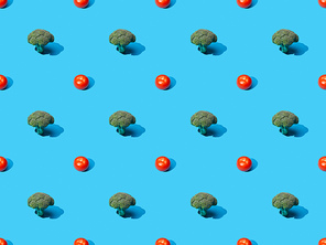 fresh green broccoli and tomatoes on blue background, seamless pattern