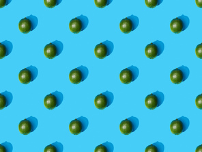 top view of fresh whole limes on blue colorful background, seamless pattern
