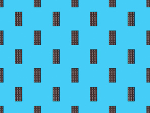 top view of sweet dark chocolate bars on blue colorful background, seamless pattern