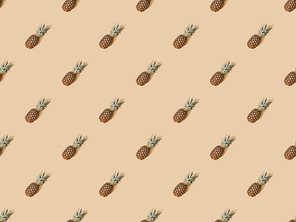 top view of whole ripe pineapples on beige background, seamless pattern