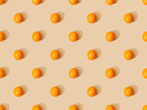 top view of ripe oranges on beige background, seamless pattern