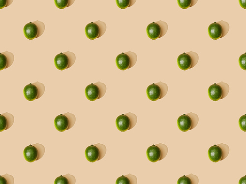 top view of fresh whole limes on beige background, seamless pattern