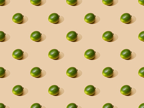 fresh whole limes on beige background, seamless pattern