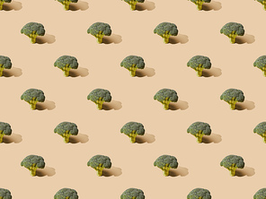 fresh green broccoli on beige background, seamless pattern
