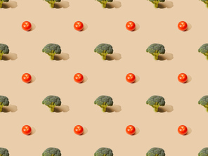 fresh green broccoli and tomatoes on beige background, seamless pattern