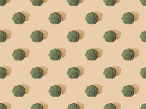 top view of fresh green broccoli on beige background, seamless pattern