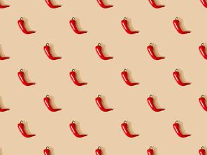 top view of red spicy chili peppers on beige background, seamless pattern