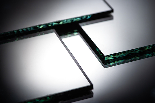 close up view of square mirror pieces in stack in dark