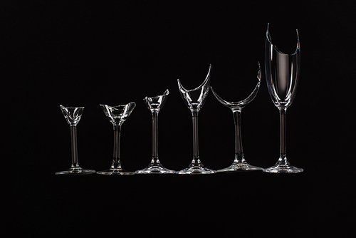 broken sharp transparent glasses in row isolated on black