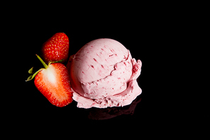 delicious pink strawberry ice cream with fresh berries isolated on black