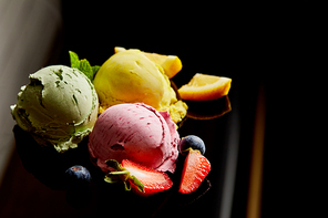 delicious lemon, berry and mint ice cream balls on black