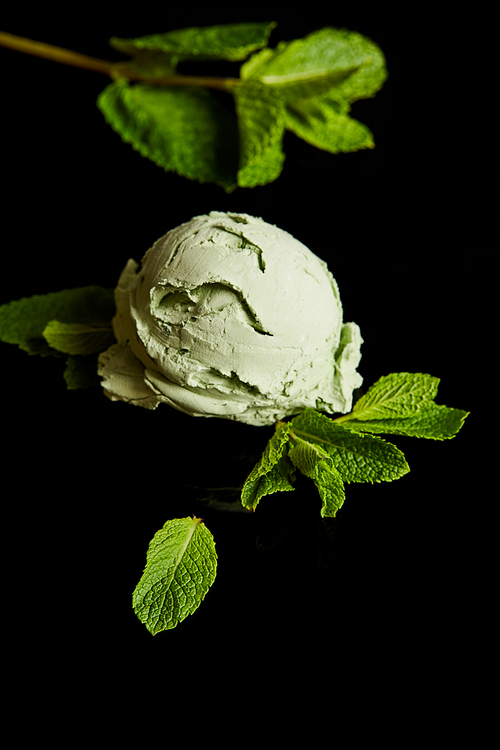 fresh delicious green mint ice cream with leaves isolated on black
