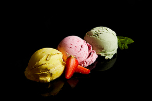 delicious lemon, strawberry and mint ice cream balls isolated on black