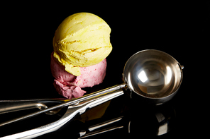 delicious lemon, strawberry ice cream balls with scoop on black