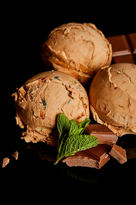 fresh delicious chocolate ice cream with mint leaves isolated on black