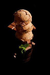fresh delicious chocolate ice cream with mint leaves isolated on black