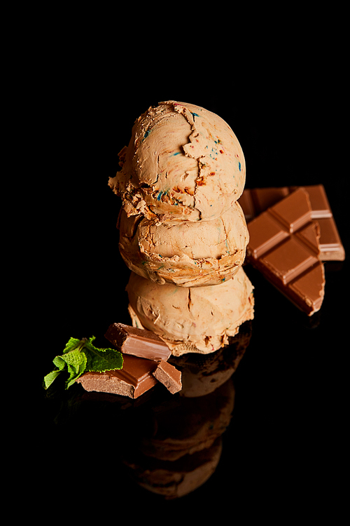 fresh delicious chocolate ice cream with mint leaves isolated on black