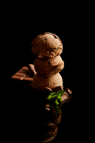 fresh delicious chocolate ice cream with mint leaves isolated on black