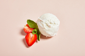 fresh tasty ice cream ball with strawberry and mint on pink background