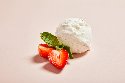 fresh tasty ice cream ball with strawberry and mint on pink background