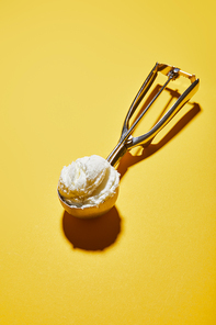 fresh tasty ice cream ball in scoop on yellow background