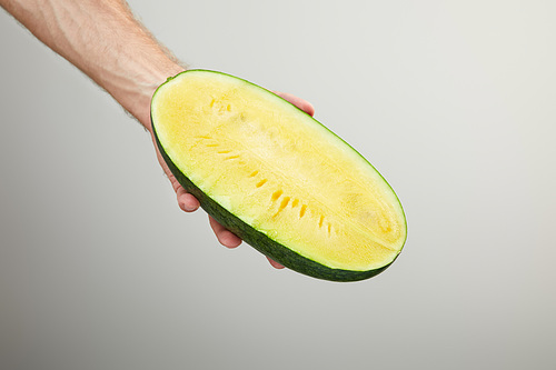 cropped view of man holding ripe yellow watermelon half isolated on grey