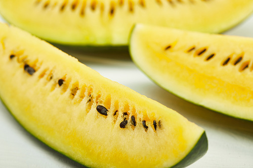 yellow tasty watermelon with seeds on white wooden table