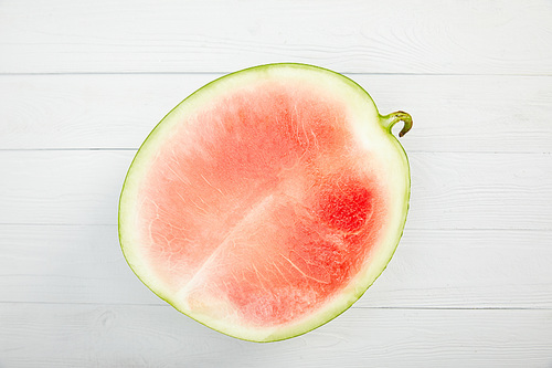 top view of ripe red watermelon half on wooden white table