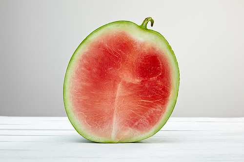 ripe red tasty watermelon half on wooden white table isolated on grey