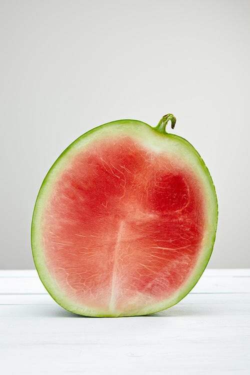 ripe red delicious watermelon half on wooden white table isolated on grey