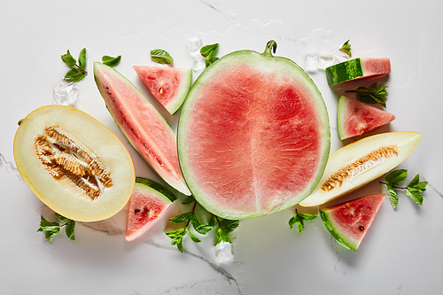 top view of cut delicious exotic red watermelon with on marble surface with ice and mint