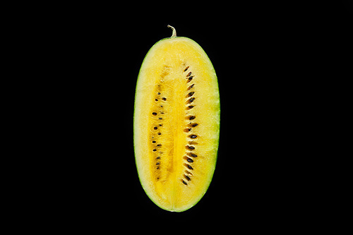 top view of delicious ripe yellow watermelon half with seeds isolated on black