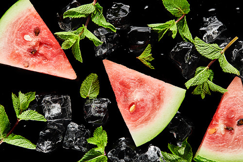 top view of red delicious watermelon slices with mint and ice isolated on black