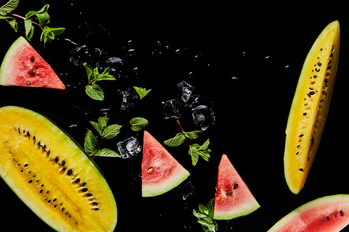 top view of red and yellow watermelon slices with mint and ice isolated on black