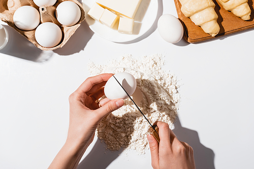 cropped view of woman making dough for croissants on white background