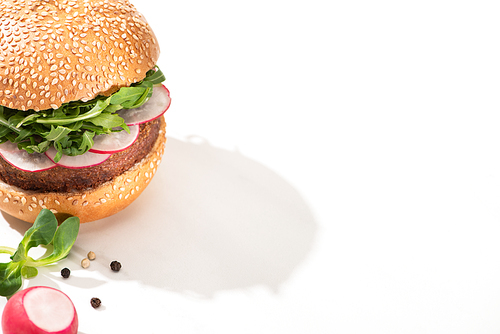 delicious vegan burger with radish and arugula with black pepper on white background