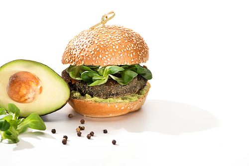 delicious green vegan burger with microgreens, avocado, black pepper on white background