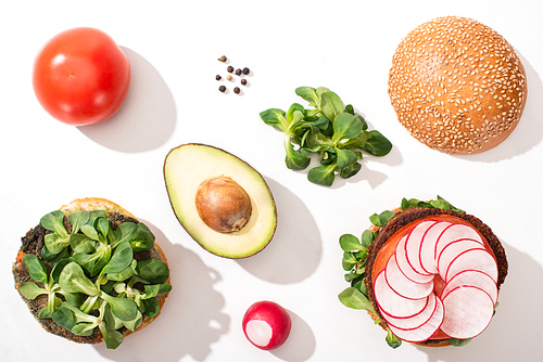 top view of vegan burgers with ingredients on white background