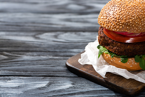 tasty vegan burger served on cutting board on wooden table