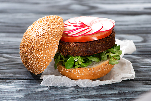 tasty vegan burger with radish served on wooden table
